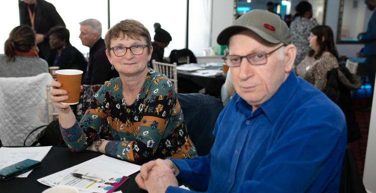 Man and woman sitting in a busy room